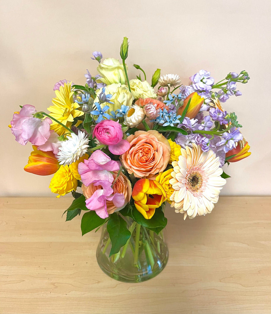 Garden roses, tulips, Gerbera daisies, sweet pea, lisianthus, ranunculus in tall vase perfect for a gift in Houston. 