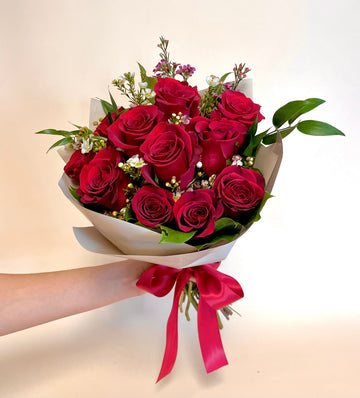 Red roses wrapped in paper tied with an elegant silk red ribbon perfect for an anniversary gift in Houston
