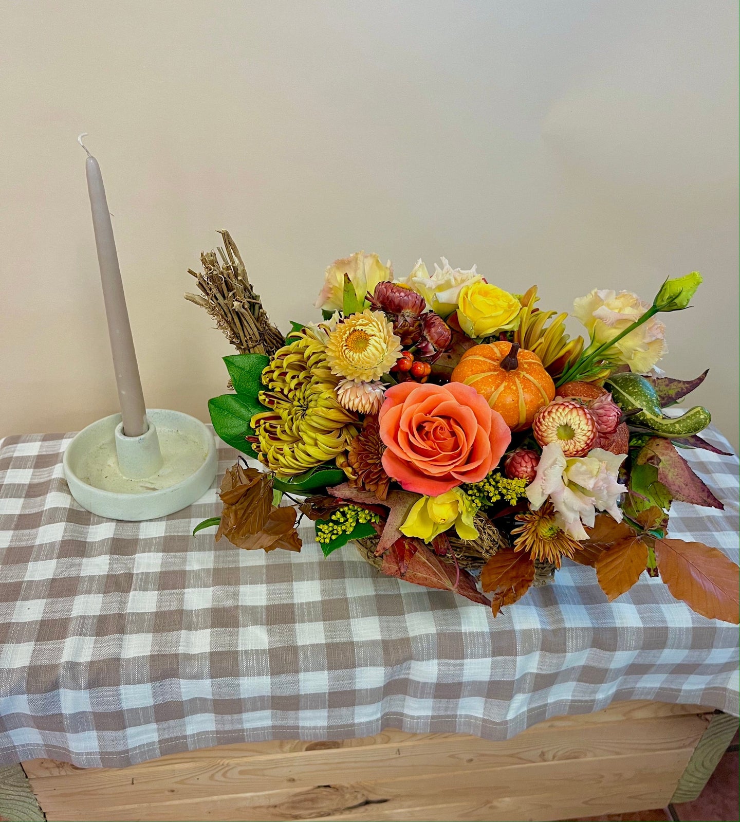 Cornucopia centerpiece with orange and yellow roses, strawflower, fall mums, and faux mini pumpkins. Thanksgiving fall centerpiece for delivery or pickup in Houston.