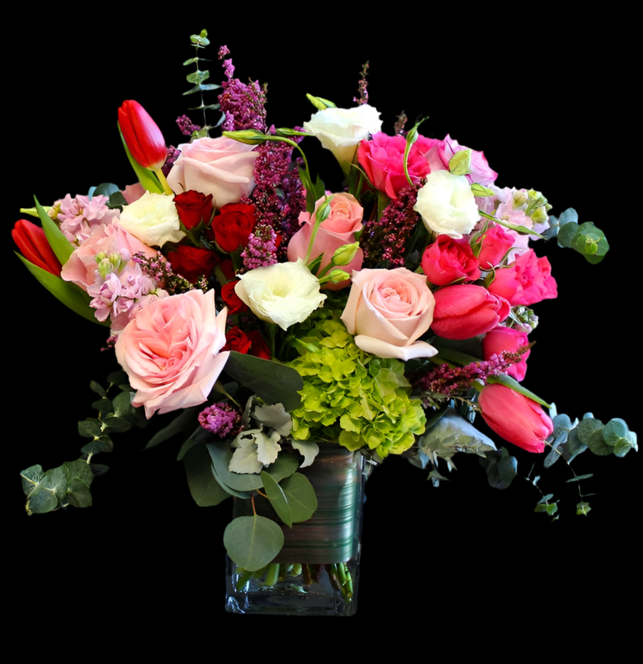 Valentine arrangement with hot pink tulips, pink roses, lisianthus, green hydrangeas, and other mixed foliage in a rectangular vase. Valentine's day flower delivery in Houston. 