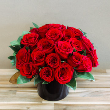24 red roses arrangement in a black vase very modern look. Anniversary roses same day delivery or pick up in Houston