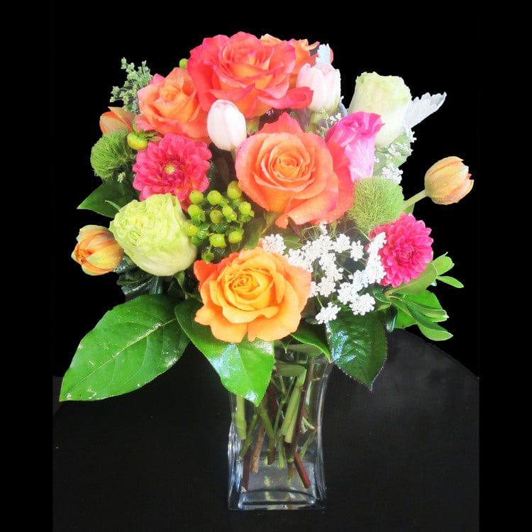 Free spirt roses, orange tulips, tulips in clear vase perfect for an anniversary gift. 