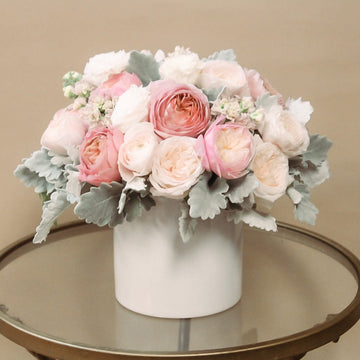 Premium flowers, white ranunculus and blush pink garden with dusty miller in white ceramic vase