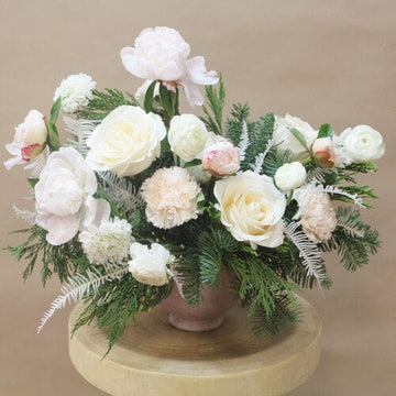 Holiday arrangement with ‘Vendela’ roses, blush peonies, white ranunculus, blush carnations, white scabiosas and evergreen greenery in a blush ceramic container. Brighten someone day in Houston, delivery and pickup available.