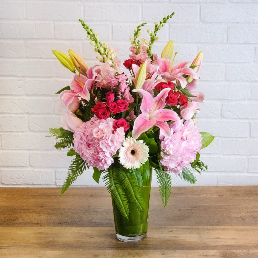 Mix of seasonal blooms like roses, snapdragons, hydrangea in a tall vase delivery today in Houston