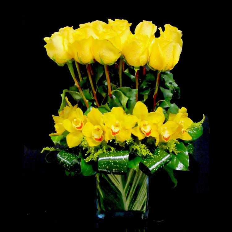 Morden design with yellow roses and cymbidium orchid in square vase with a green leaf wrapped. Birthday flowers in Houston. Available for pick up or delivery in Houston .
